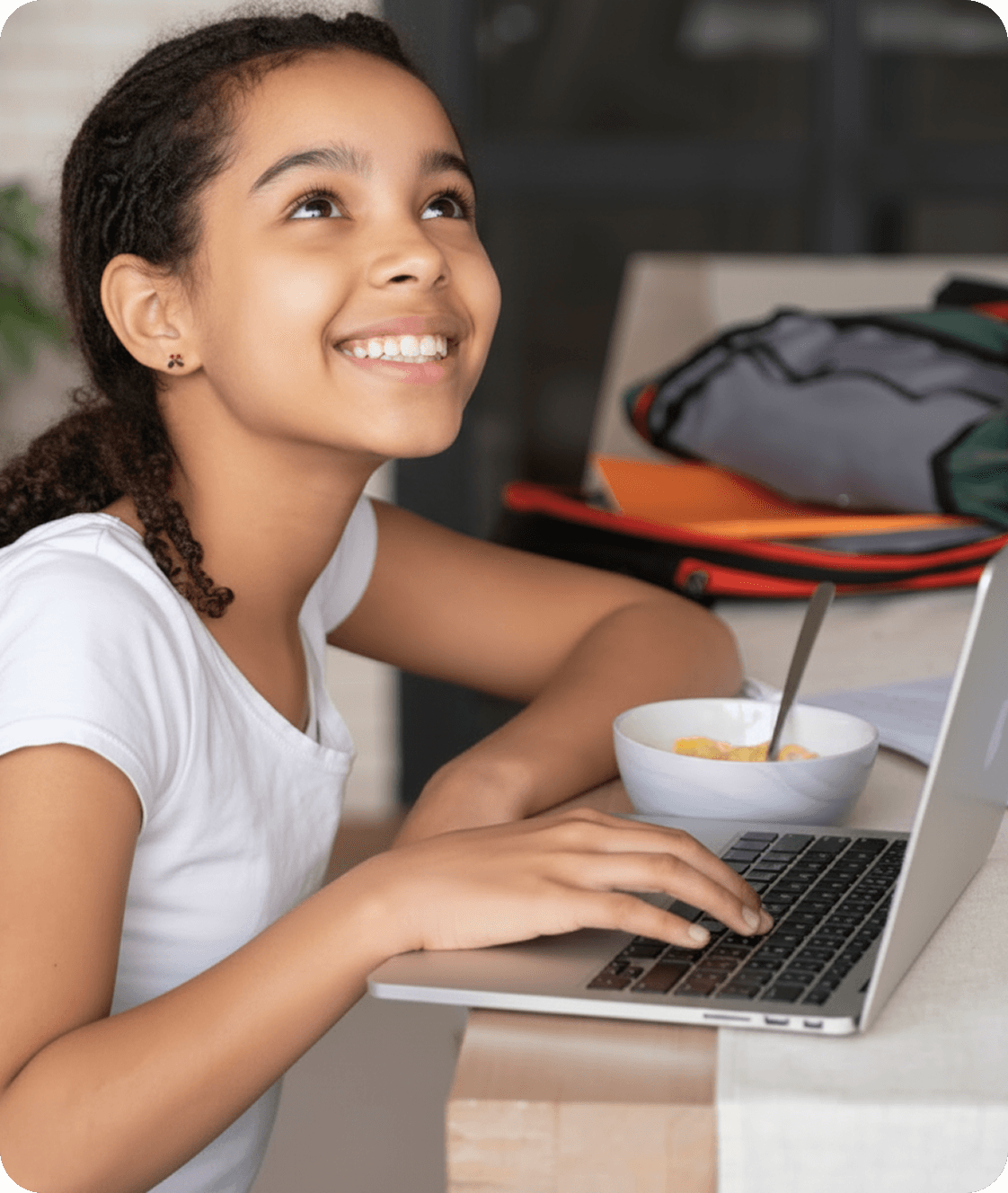 Student smiling while using a laptop